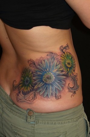 John Garancheski III - flowers with filigree accents on side of back tattoo