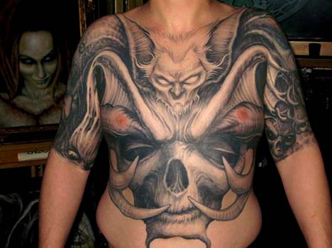 Bat face with horned skulll chest and stomach tattoo